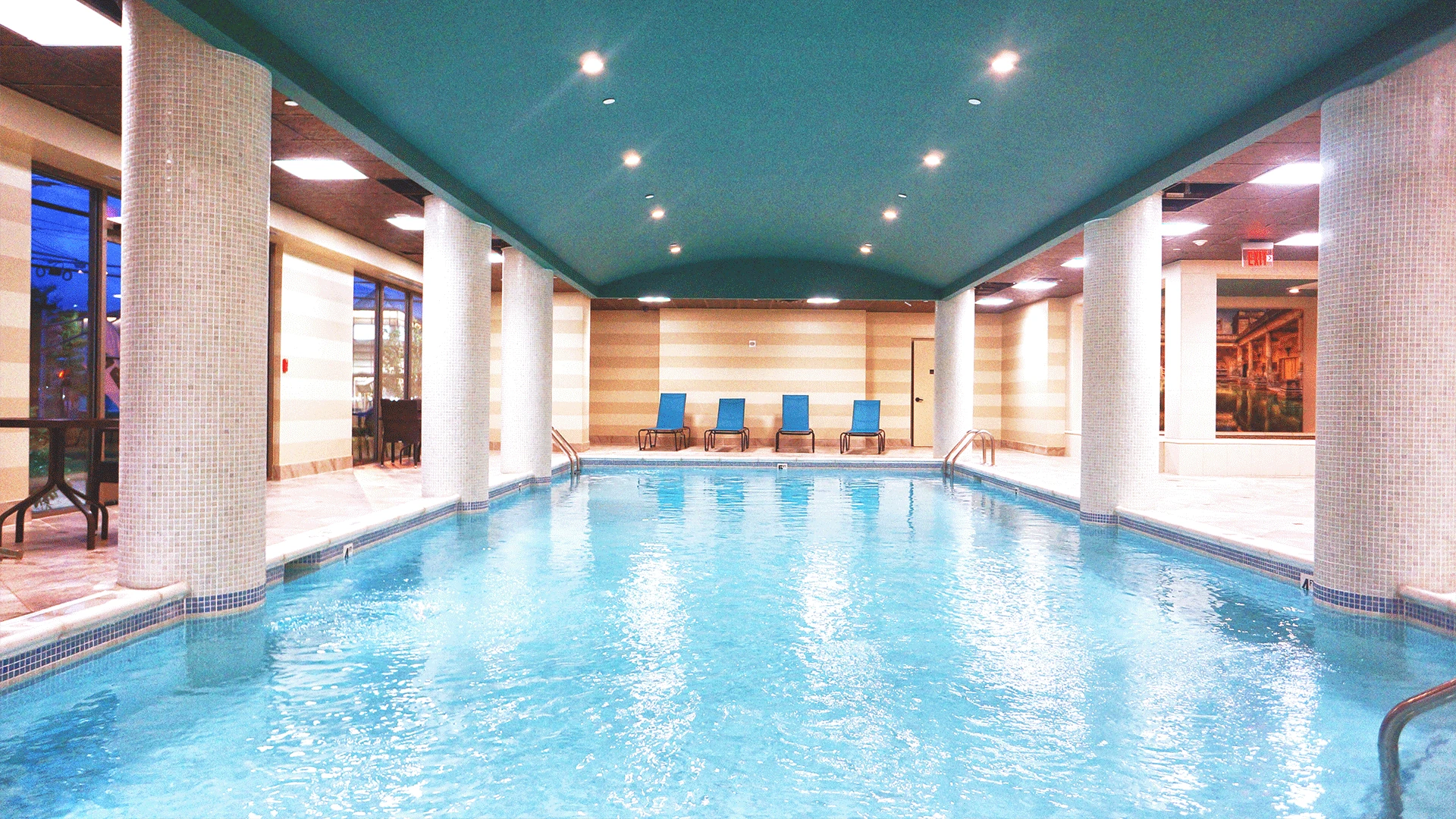 Indoor swimming pool with columns and turquoise water